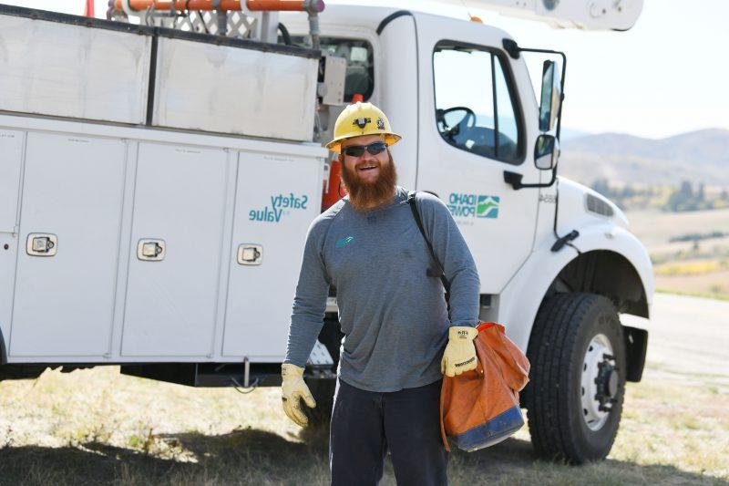 图为一名生产线工人在爱达荷州动力铲斗卡车前.